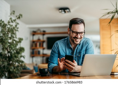 Portrait of a happy man with smart phone and laptop, indoors. - Shutterstock ID 1765866983