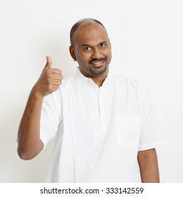 Portrait Of Happy Mature Casual Business Indian Man Thumb Up, Standing On Plain Background With Shadow.