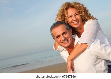 Portrait Of Happy Mature Couple At The Beach