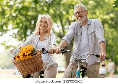 Portrait Of Happy Mature Couple Riding Retro Bicycles In Summer Park, Cheerful Senior Spouses Having Fun Together Outdoors, Smiling Elderly Man And Woman Enjoying Free Time On Retirement, Closeup - Powered by Shutterstock