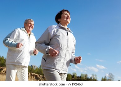 Portrait Of Happy Mature Couple Running Together