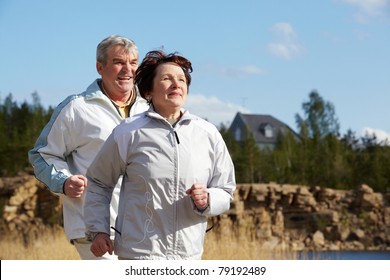 Portrait Of Happy Mature Couple Running Together