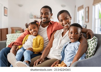 Portrait of happy mature couple with son and daughter relaxing on sofa at home. Middle aged black woman with husband and children smiling and looking at camera. Beautiful mid african american family. - Powered by Shutterstock