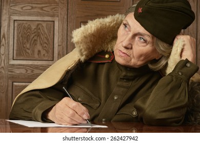 Portrait Of A Happy Mature Female Soldier Writing Letter