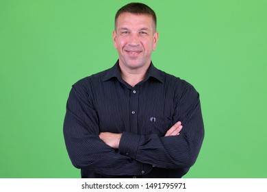 Portrait of happy mature macho businessman smiling with arms crossed - Powered by Shutterstock