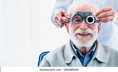 Portrait of a happy mature male patient undergoing vision check with special ophthalmic glasses