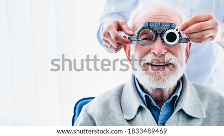 Portrait of a happy mature male patient undergoing vision check with special ophthalmic glasses Stok fotoğraf © 