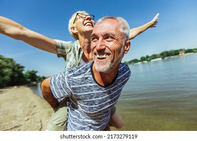 Portrait of happy mature man being embraced by his wife at the beach.  - Shutterstock ID 2173279119