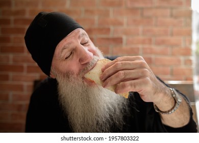 Portrait Of Happy Mature Man With Long Gray Beard Eating Taco