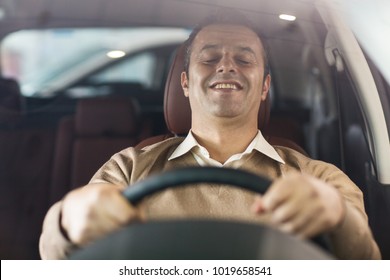 Portrait Of A Happy Mature Man Sitting In A Car Holding Steering Wheel Smiling With His Eyes Closed Pleasure Enjoyment Emotions Lifestyle Luxury Driver Travelling Positivity Excitement Satisfaction