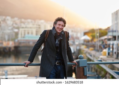 Portrait happy mature man smiling enjoying urban lifestyle in city with waterfront harbour in background