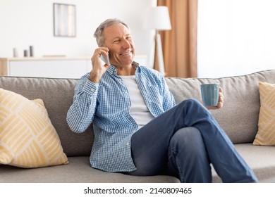 Portrait Of Happy Mature Man Talking On Mobile Phone Sitting On Couch At Home. Cheerful Adult Male Speaking, Having Cellphone Conversation Indoors. Modern Communication, People And Gadgets Concept - Powered by Shutterstock