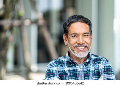 Portrait of happy mature man with white, grey stylish short beard looking at camera outdoor. Casual lifestyle of retired hispanic people or adult asian man smile with confident at coffee shop cafe.
