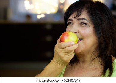 Portrait Of Happy Mature Woman Eating Apple