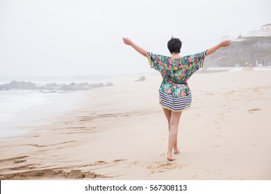 Portrait Of A Happy Mature Woman With Outspread Arms Enjoying Freedom On The Ocean Beach. Freedom Of Travel Vacation. Wellness And Happiness Lifestyle Concept. Portugal. Santa Cruz