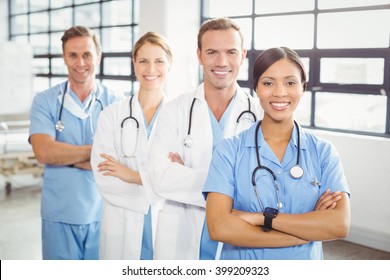 Portrait Of Happy Medical Team Standing With Arms Crossed In Hospital