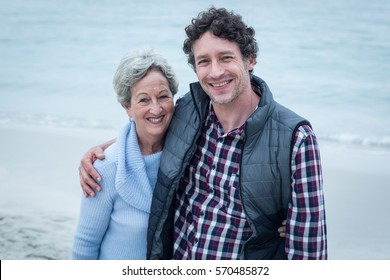 Portrait of happy mid adult man with mother at sea shore