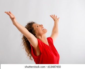 Portrait Of A Happy Middle Aged Brunette With Arms Up