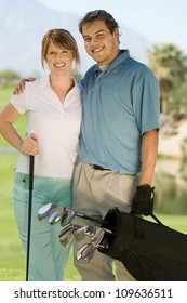 Portrait Of A Happy Middle Aged Couple Carrying Golf Bag On Golf Course