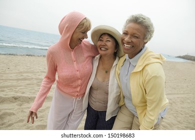 Portrait of happy middle aged female friends enjoying vacation at beach