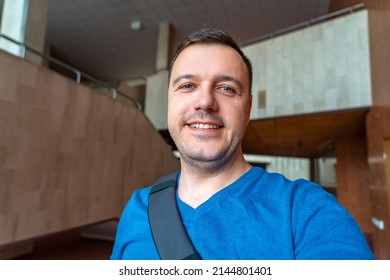 Portrait of happy middle aged man, standing in office lobby wearing casual pullover. Portrait of confident millenial man smiling and looking at camera. - Shutterstock ID 2144801401