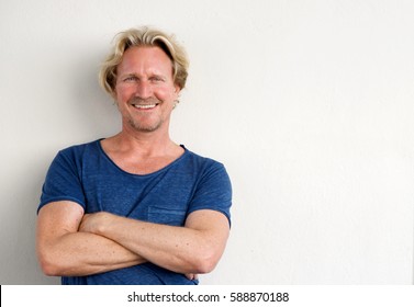 Portrait Of Happy Middle Aged Man Posing With Arms Crossed Against White Background