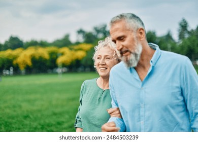 Portrait of a happy middle aged woman and  active middle aged white couple having fun walking holding hands and bonding in park outdoors - Powered by Shutterstock