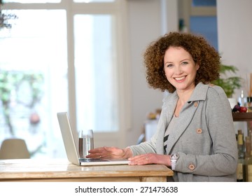 Portrait Of A Happy Middle Aged Woman Using Laptop At Home