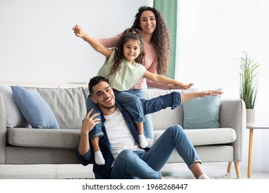 Portrait Of Happy Middle Eastern Parents Bonding With Their Child At Home, Happy Arab Family With Daughter Having Fun In Living Room, Playing And Laughing, Enjoying Spending Time Together, Free Space - Shutterstock ID 1968268447