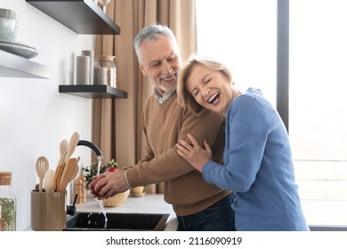 Portrait von glücklichem Paar mittleren Alters in der modernen, gemütlichen Küche. Frauen, die über die Witze ihres Mannes lachen. Fröhliche Familie. Für immer Liebeskonzept. Modernes Wohnungswesen