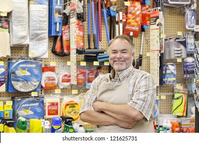 Portrait Of A Happy Middle-aged Salesperson With Arms Crossed In Hardware Store