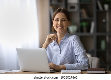 Portrait of happy millennial Caucasian businesswoman work on laptop online at home office. smiling young woman employee or worker consult client partner distant on computer. Technology concept.