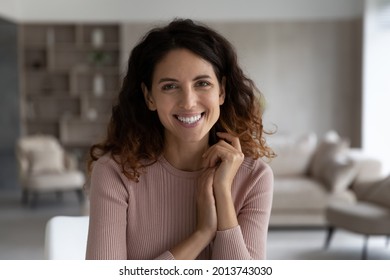 Portrait Of Happy Millennial Hispanic Female Tenant Or Renter Sit Pose In Modern Renovated Home Or Apartment Alone. Smiling Young Latino Woman Laugh Feel Optimistic Relax Rest. Diversity Concept.