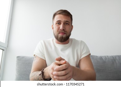 Portrait of happy millennial man making video call on laptop sitting on couch at home, young mentor or trainer record online webinar or training, male communicate or broadcast live on computer