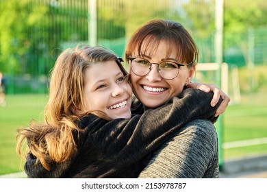 Portrait Of Happy Mom And Preteen Daughter Hugging Together Outdoor