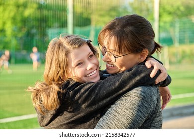 Portrait Of Happy Mom And Preteen Daughter Hugging Together Outdoor