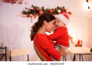 Portrait Of Happy Mother And Adorable Baby Celebrate Christmas. New Year's Holidays. Toddler With Mom In The Festively Decorated Room.