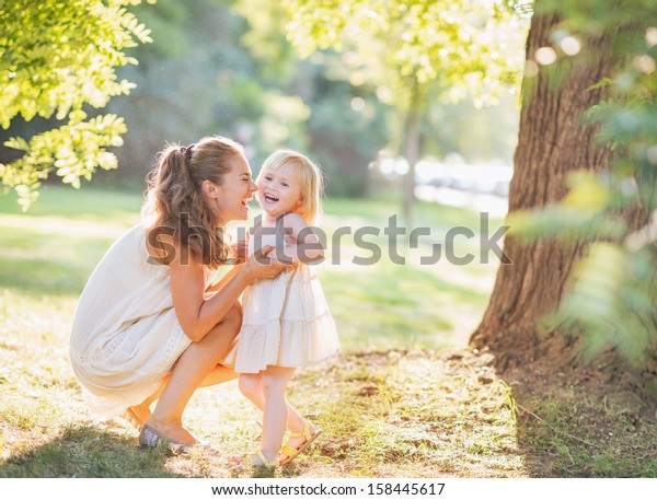 Portrait of happy mother and baby playing outdoors