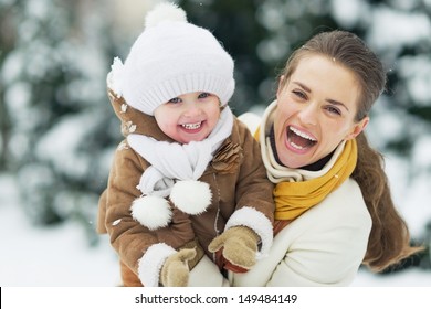 Portrait Of Happy Mother And Baby In Winter Park