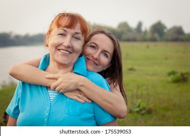 Portrait of happy mother and daughter in nature, hug, smile, outdoor