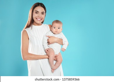 Portrait Of Happy Mother With Her Baby On Color Background. Space For Text