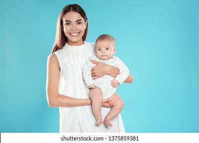 Portrait Of Happy Mother With Her Baby On Color Background. Space For Text