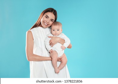 Portrait Of Happy Mother With Her Baby On Color Background. Space For Text