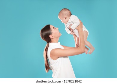 Portrait Of Happy Mother With Her Baby On Color Background