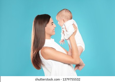 Portrait Of Happy Mother With Her Baby On Color Background