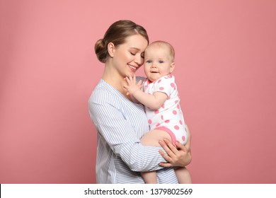 Portrait Of Happy Mother With Her Baby On Color Background