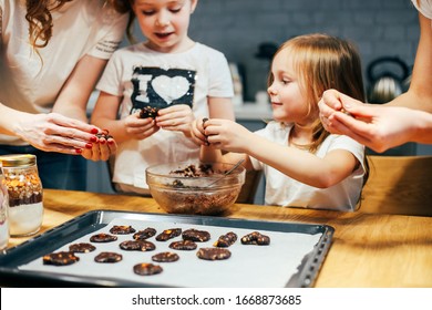 Portrait Of Happy Mothers And Two Daughters Cooking In The Kitchen