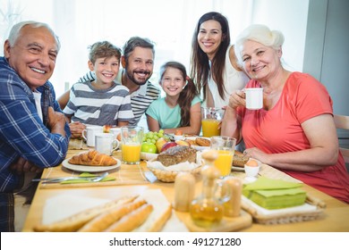 Portrait of happy multi-generation family sitting at breakfast table in home - Powered by Shutterstock