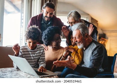 Portrait of a happy multigeneration family using electronic devices at home together - Powered by Shutterstock
