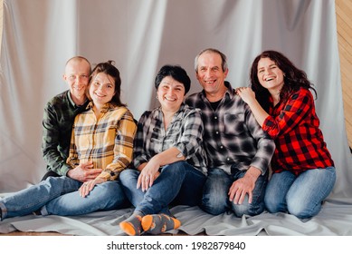 Portrait Of Happy Multigenerational Family Sitting On Sofa In Living Room At Home